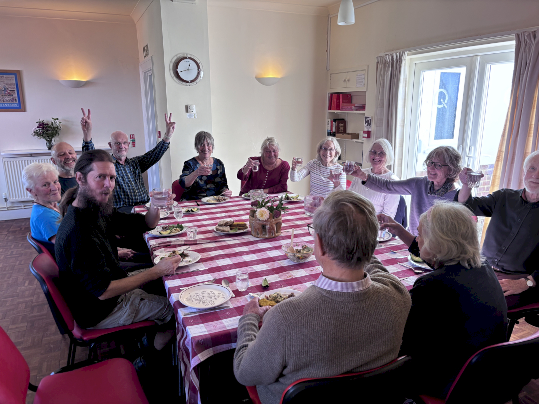 quakers round a table smiling at the camera