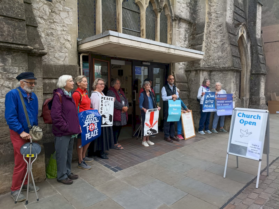 quakers and others standing in a peace vigil outside a church